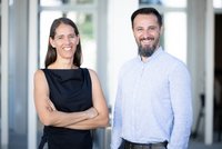 Eine Frau und ein Mann stehen nebeneinander und schauen in die Kamera.