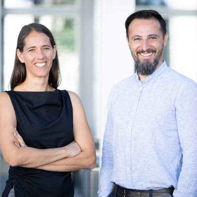 Eine Frau und ein Mann stehen nebeneinander und schauen in die Kamera.