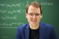 Andreas Deutschmann-Olek vor einer Tafel