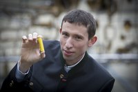 Stefan Freunberger, ERC Grant Träger der TU Graz, hält eine kleine gelbe Batterie ins Bild.