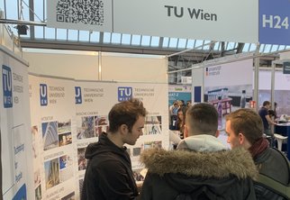 Beratung zweier junger Männer beim Infostand der TU Wien.