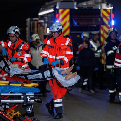 Übungsszenario im Tunnel mit Sanitätern und Verletzten auf einer Trage.