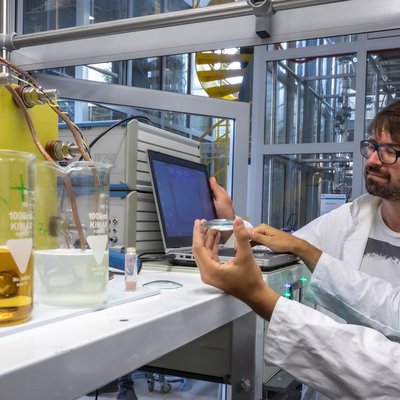 Zwei Forscher der TU Graz vor einem Versuchsaufbau mit Redox Flow Elektrolyte