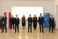 Gruppenfoto der Sub auspiciis Absolvent_innen mit Rektorin Seidler, Vizerektor Matyas und Bürgermeister Ludwig vor TU Wien Logo