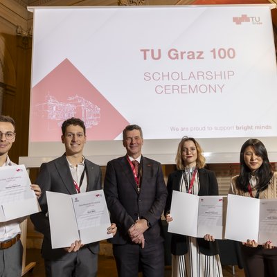 Fünf Menschen stehen nebeneinander und schauen in die Kamera, vier von ihnen halten Urkunden in ihren Händen.