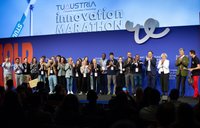 Studierende stehen vor Publikum auf einer Bühne.