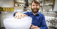 Bärtiger Mann mit Eisblock im Labor