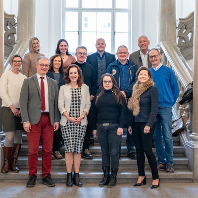 Gruppenbild der Verantwortlichen für die Kulturkoordination zwischen Montanuniversität und der Stadt Leoben auf einer Treppe im Universitätsgebäude.