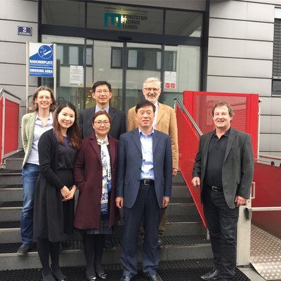 Gruppenfoto auf den Stufen vor dem Zentrum für Kunststofftechnik, aufgenommen beim Besuch einer hochrangigen Delegation der ECUST an der Leobener Kunststofftechnik zur Ausarbeitung des Curriculums für das Studienprogramm. Von links oben: Prof. Clara Sch