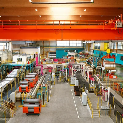 Produktionshalle im AMAG-Werk Ranshofen mit Anlagen zur Verarbeitung und Walzung von Aluminium sowie aufgerollten Aluminiumblechen.