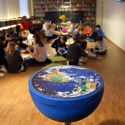 Eine Gruppe Kinder sitzen bei einer TUForMath-Veranstaltungen zusammen.