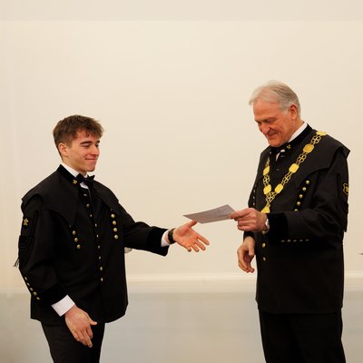 Peter Moser übergibt den Martrikelschein.