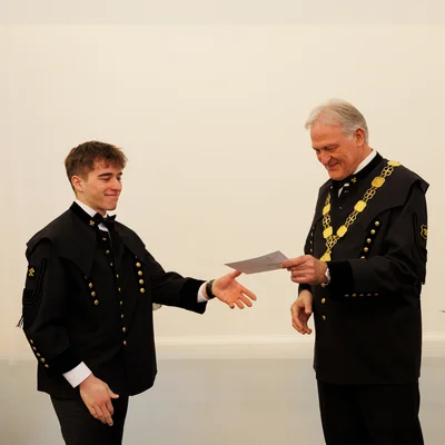 Peter Moser übergibt den Martrikelschein.