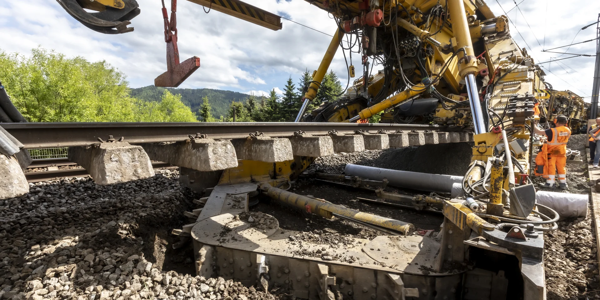 Gleisbaumaschine, Bildquelle: Lunghammer - TU Graz Ausschnitt einer Baumaschine auf Schienen, die ein Stück eines Gleiskörpers anhebt.