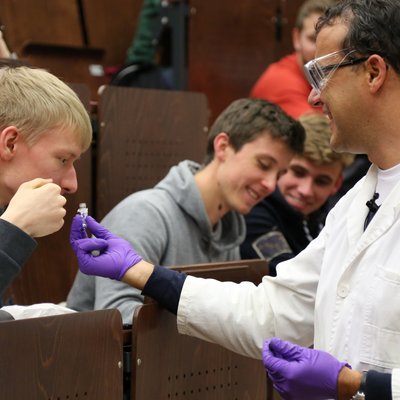 Lehrender mit Studierenden im Hörsaal